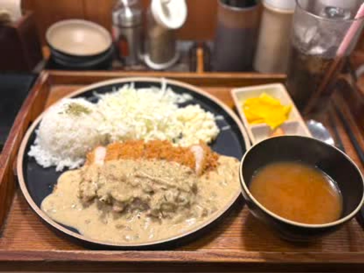 A sauce-covered katsu plate with rice, cabbage, soup, and pickles at Katsup Hongdae