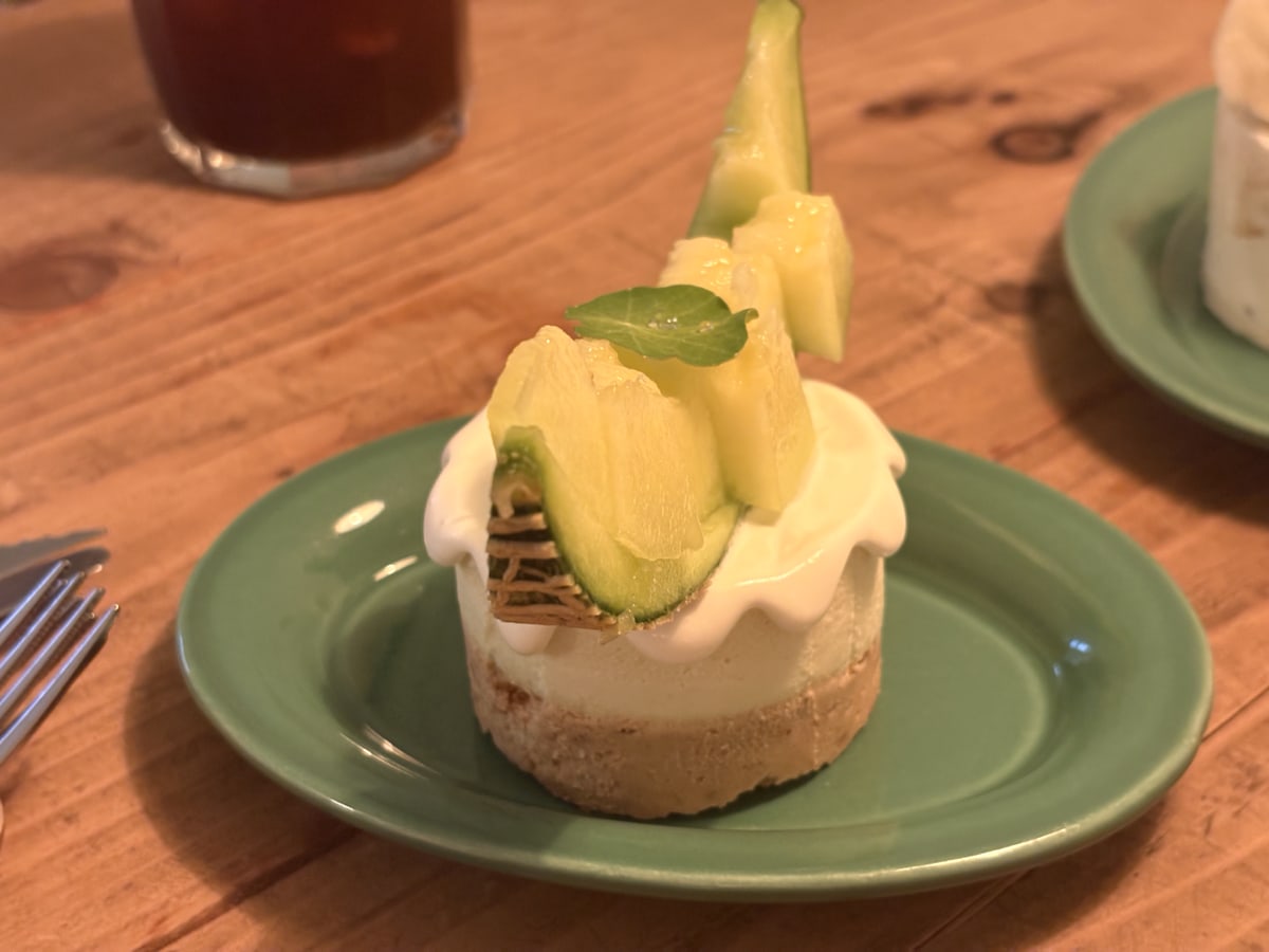 Fruit-topped cream cake and cafe drinks on a wooden table at a Yeonnam-dong cafe in Seoul.