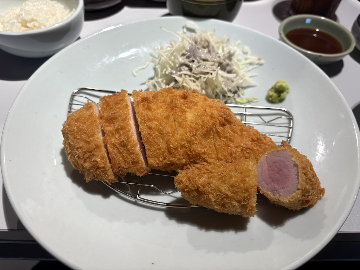 A sliced pork katsu plate with rice, cabbage, wasabi, and sauce at Heki Mangwon in Seoul